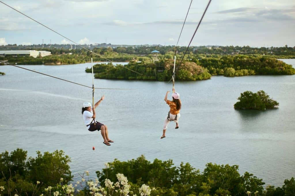 People Ziplining above Water